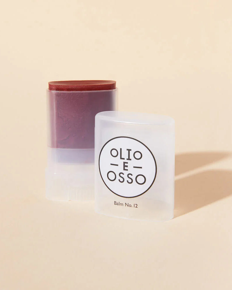Two cylindrical containers with 'Olio E Osso' branding on a beige background