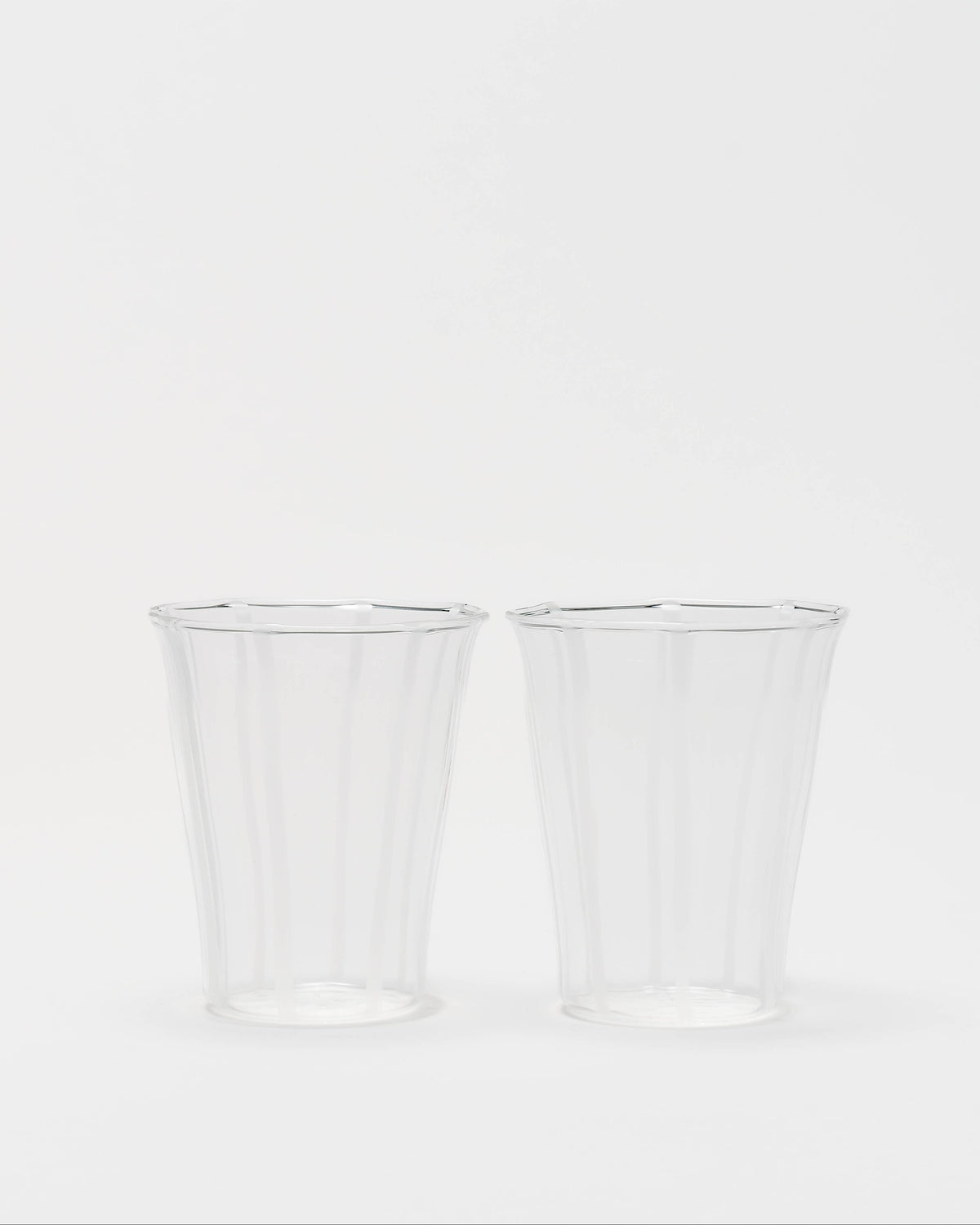 Two clear ribbed plastic cups on a plain white background.