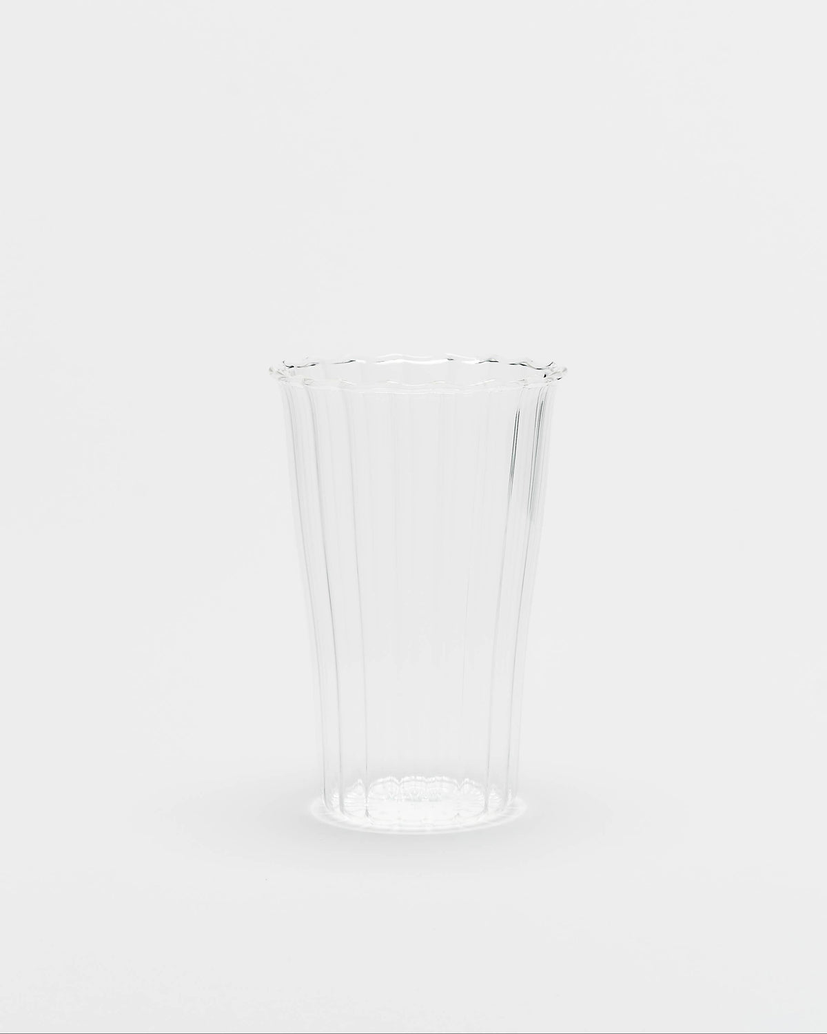 A clear ribbed plastic cup with a flared rim, shown on a seamless light gray background.