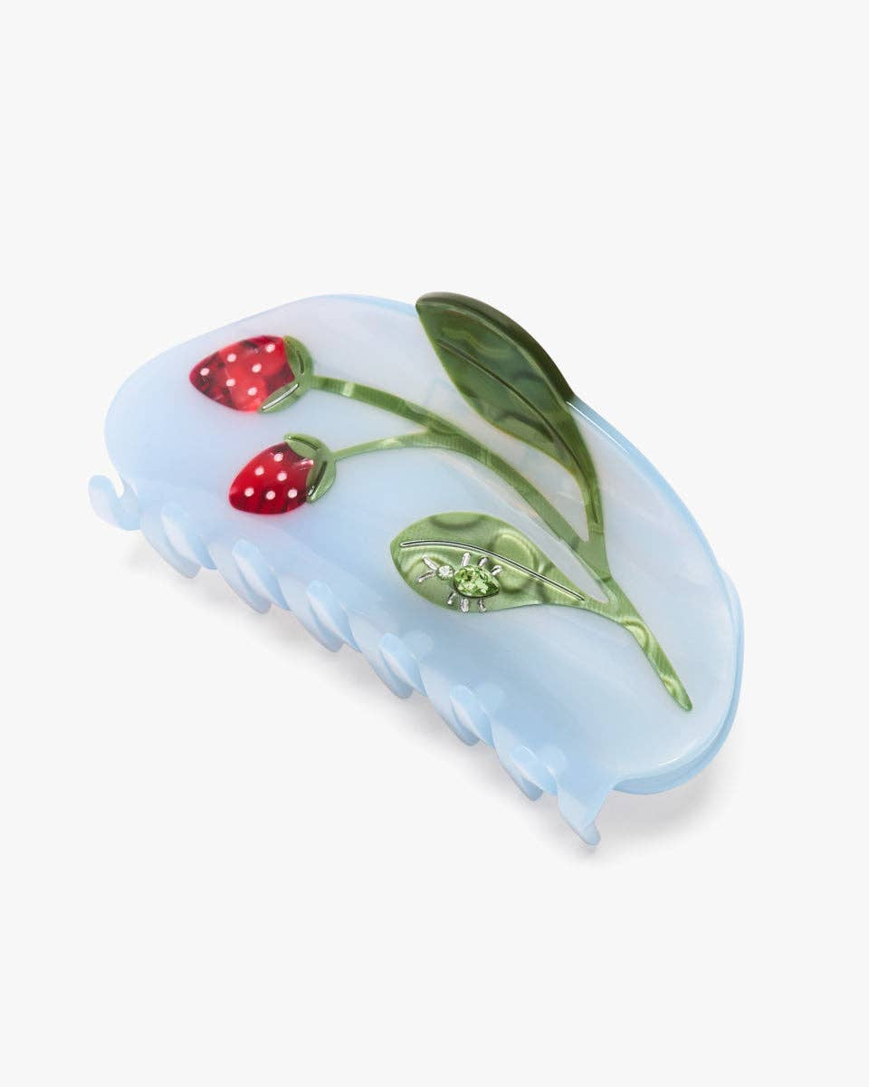 Blue hair comb with strawberry and leaf design on a white background