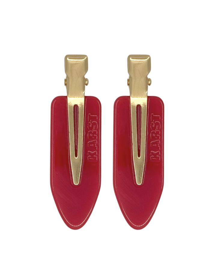Two red hair clips with gold clips on a white background