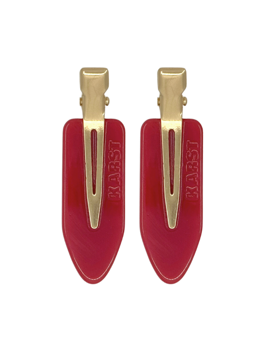 Two red hair clips with gold clips on a white background