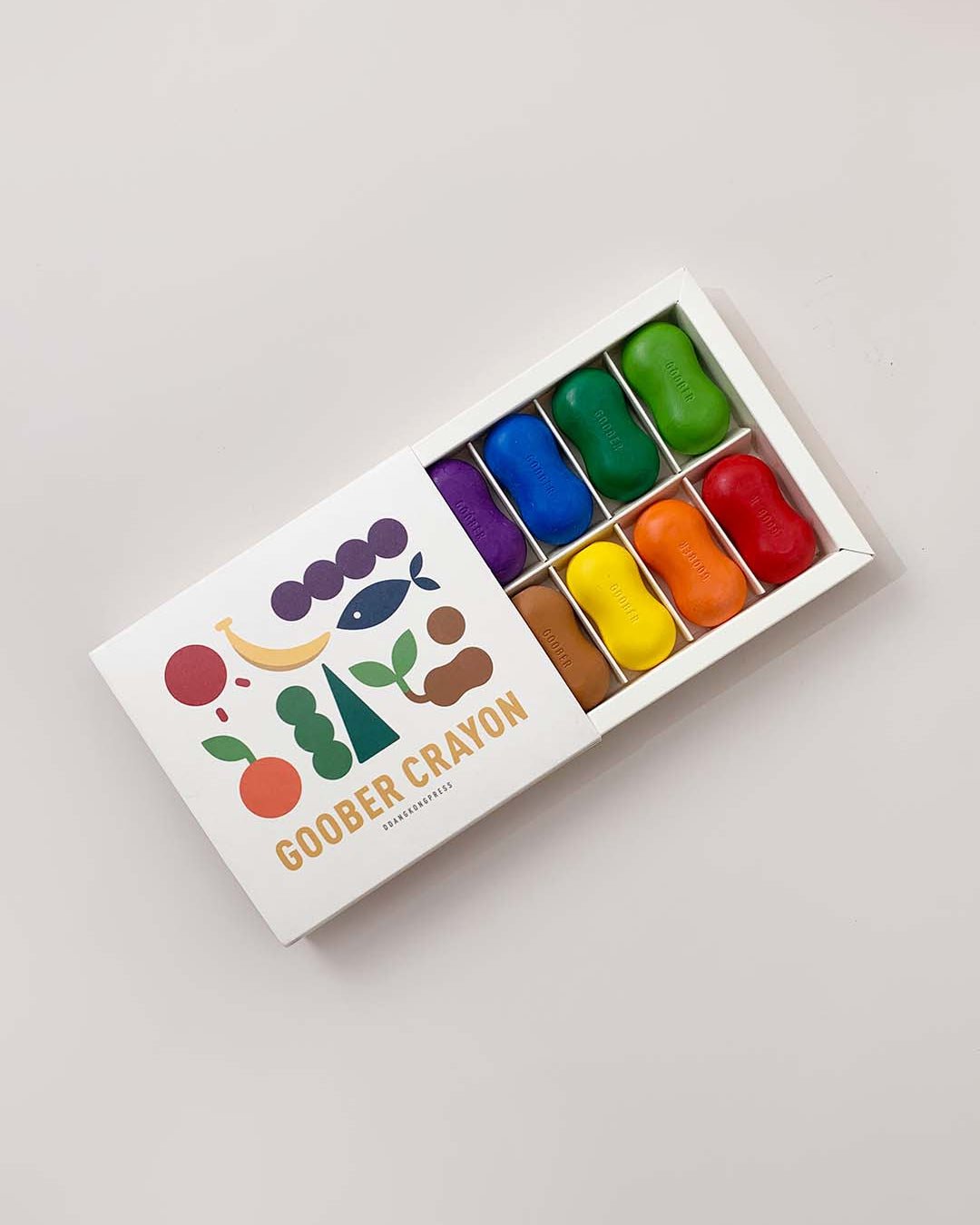 Box of colorful Goobers Crayons on a light gray background