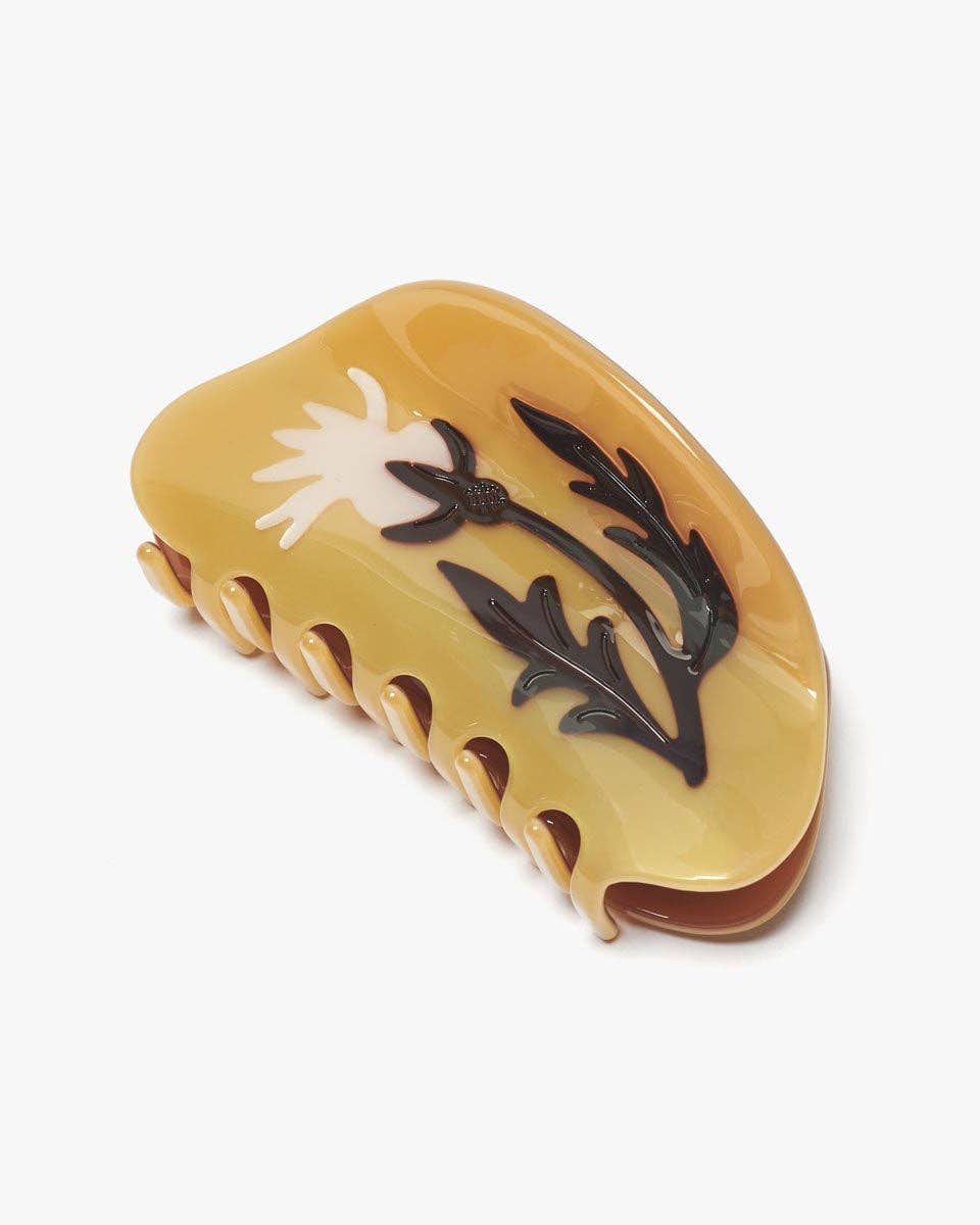 Yellow hair clip with floral design on a white background