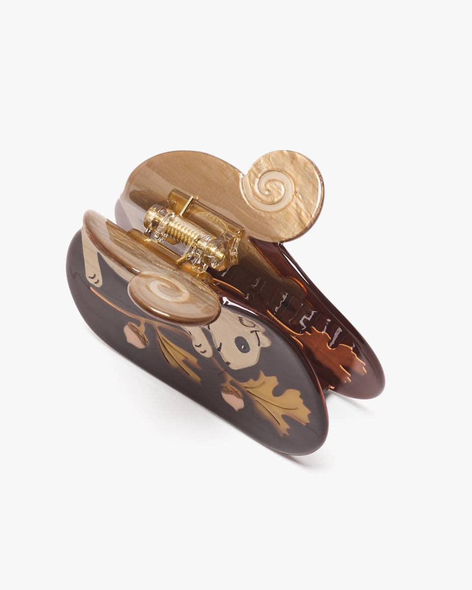 Decorative hair clip with gold and brown design on a white background