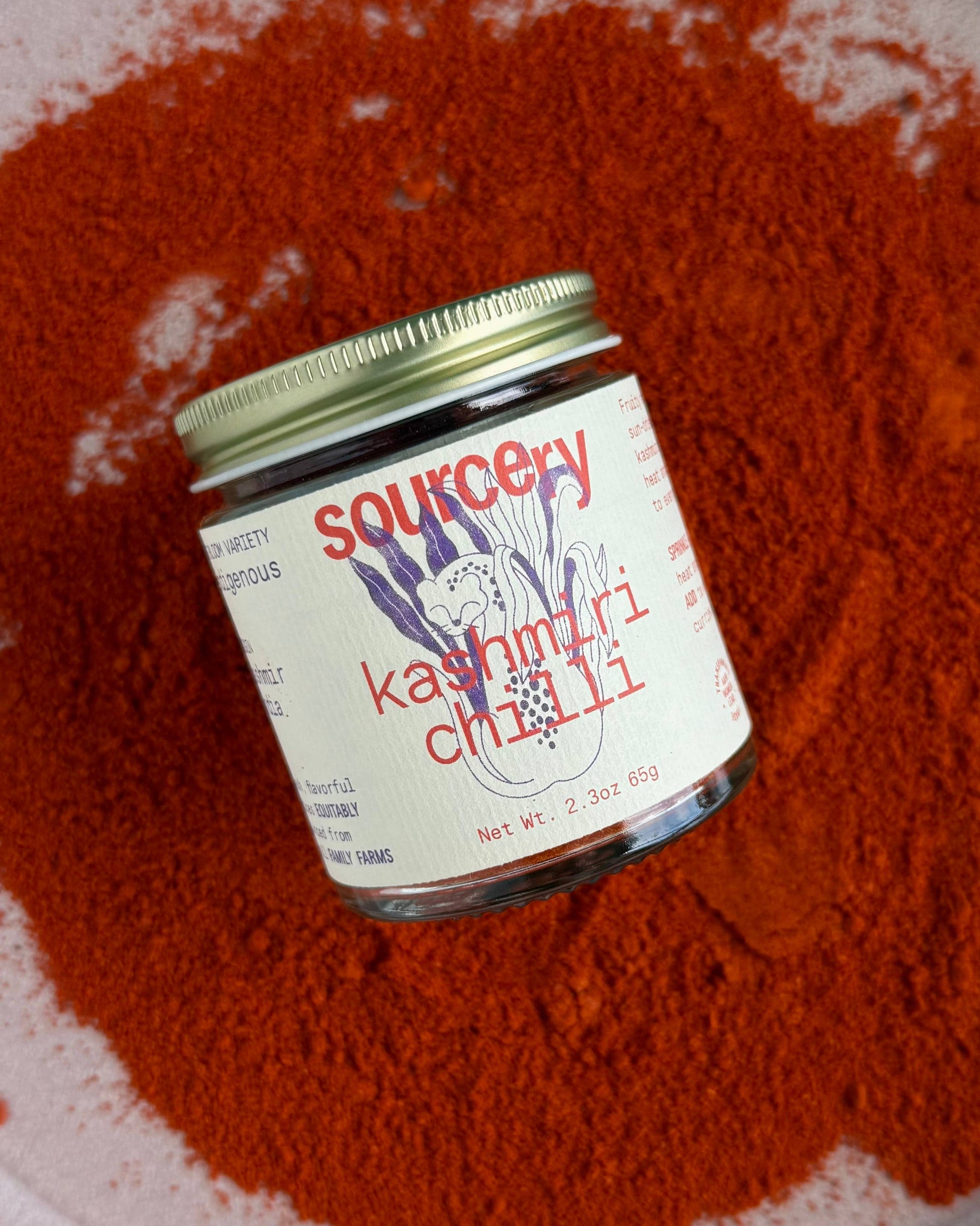 Jar of Sourcing Kashmiri Chilli on a bed of red chili powder