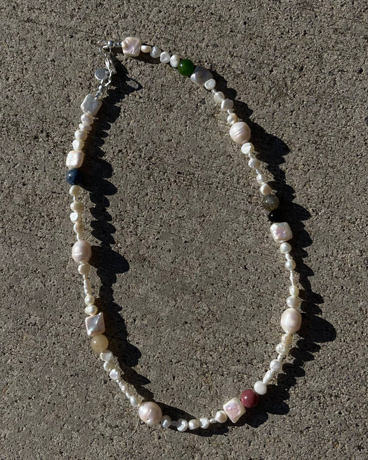 Necklace with various beads on a concrete surface