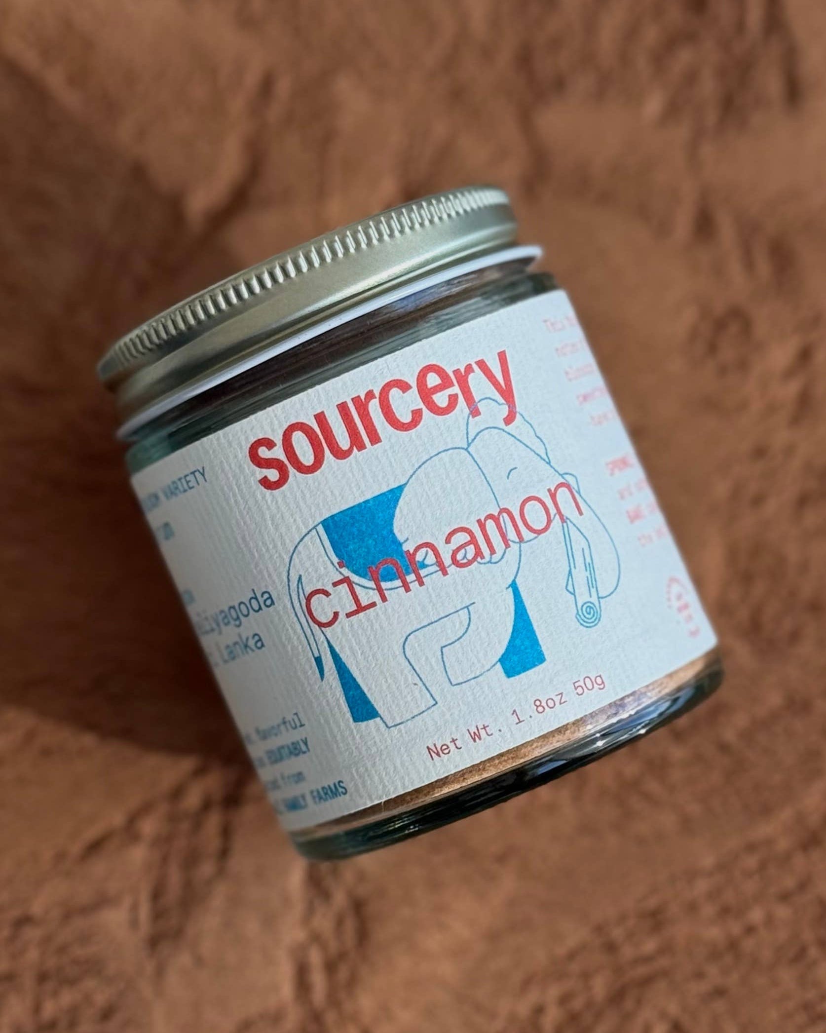 Jar of sourcery cinnamon on a brown textured surface