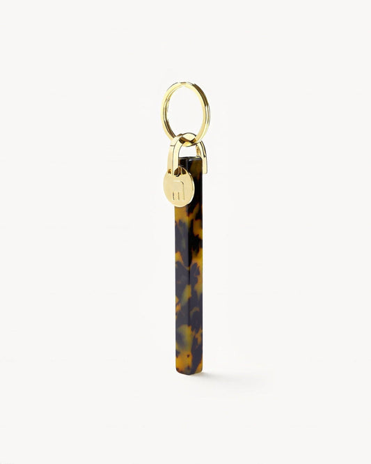 Tortoiseshell keychain with gold lock on a white background