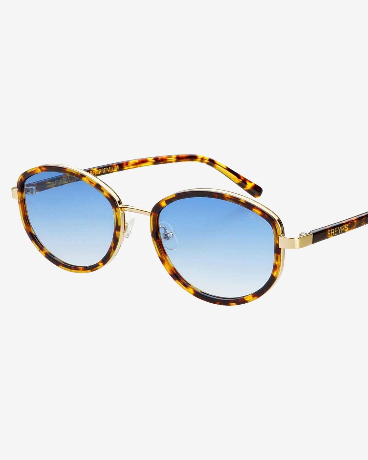 Sunglasses with tortoiseshell frame and blue gradient lenses on a white background