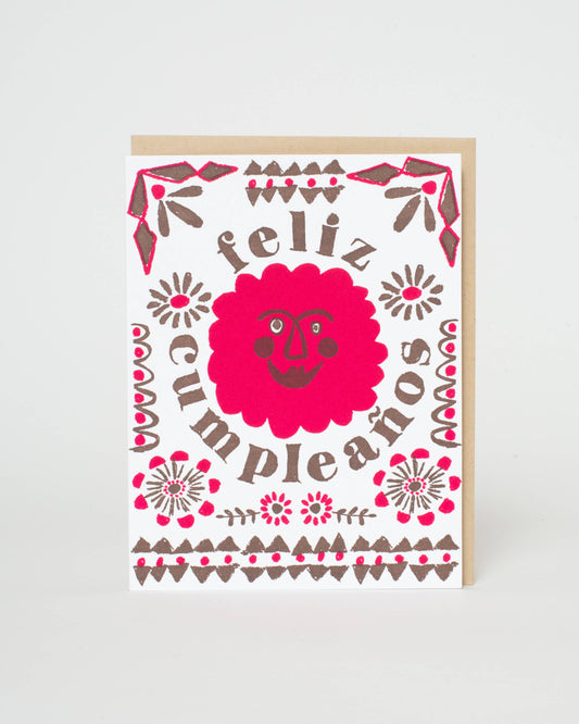 Greeting card with 'feliz cumpleaños' text and decorative elements on a white background