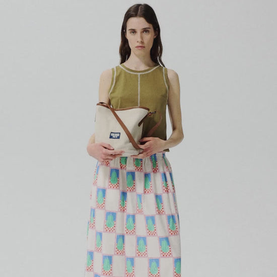 Woman holding a patterned bag against a plain background