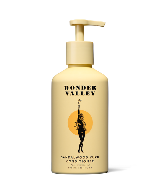 Yellow conditioner bottle with pump labeled 'Wonder Valley' on a white background