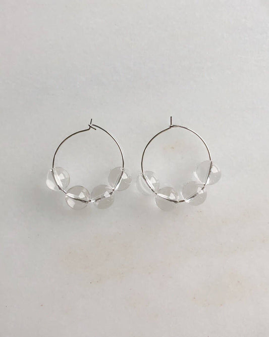 Silver hoop earrings on a light gray background