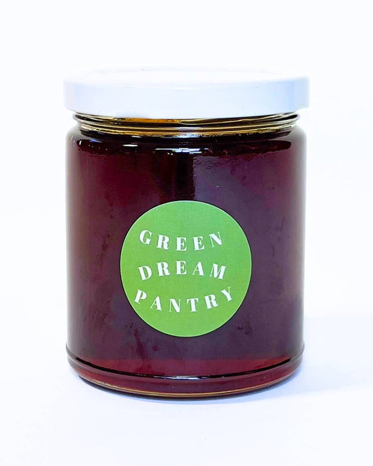 Jar of jam with a green label on a white background