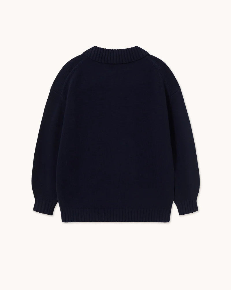 A dark navy blue knit sweater shown from the back, featuring a crew neck and ribbed cuffs and hem, displayed against a solid off-white background.