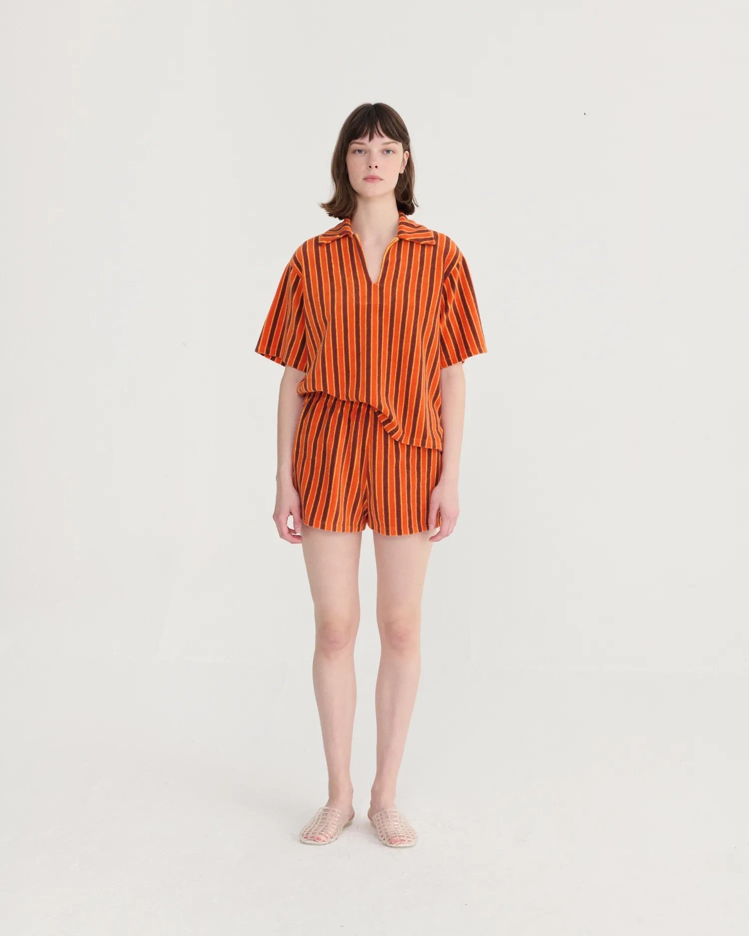 Woman wearing an orange and black striped outfit on a white background