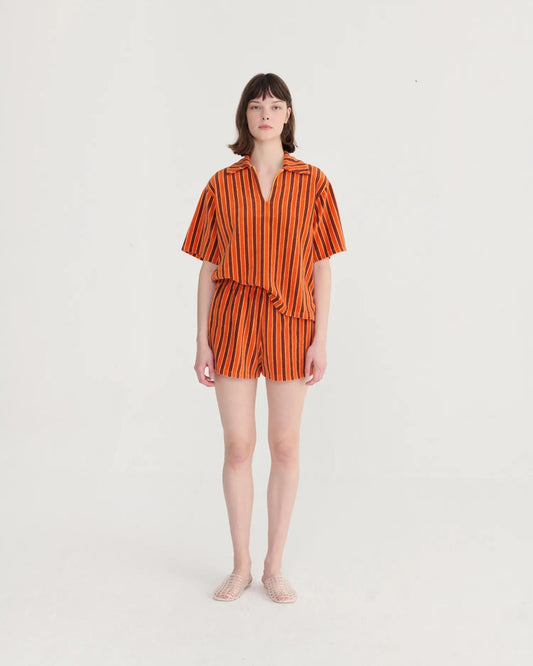 Woman wearing an orange and black striped outfit on a white background