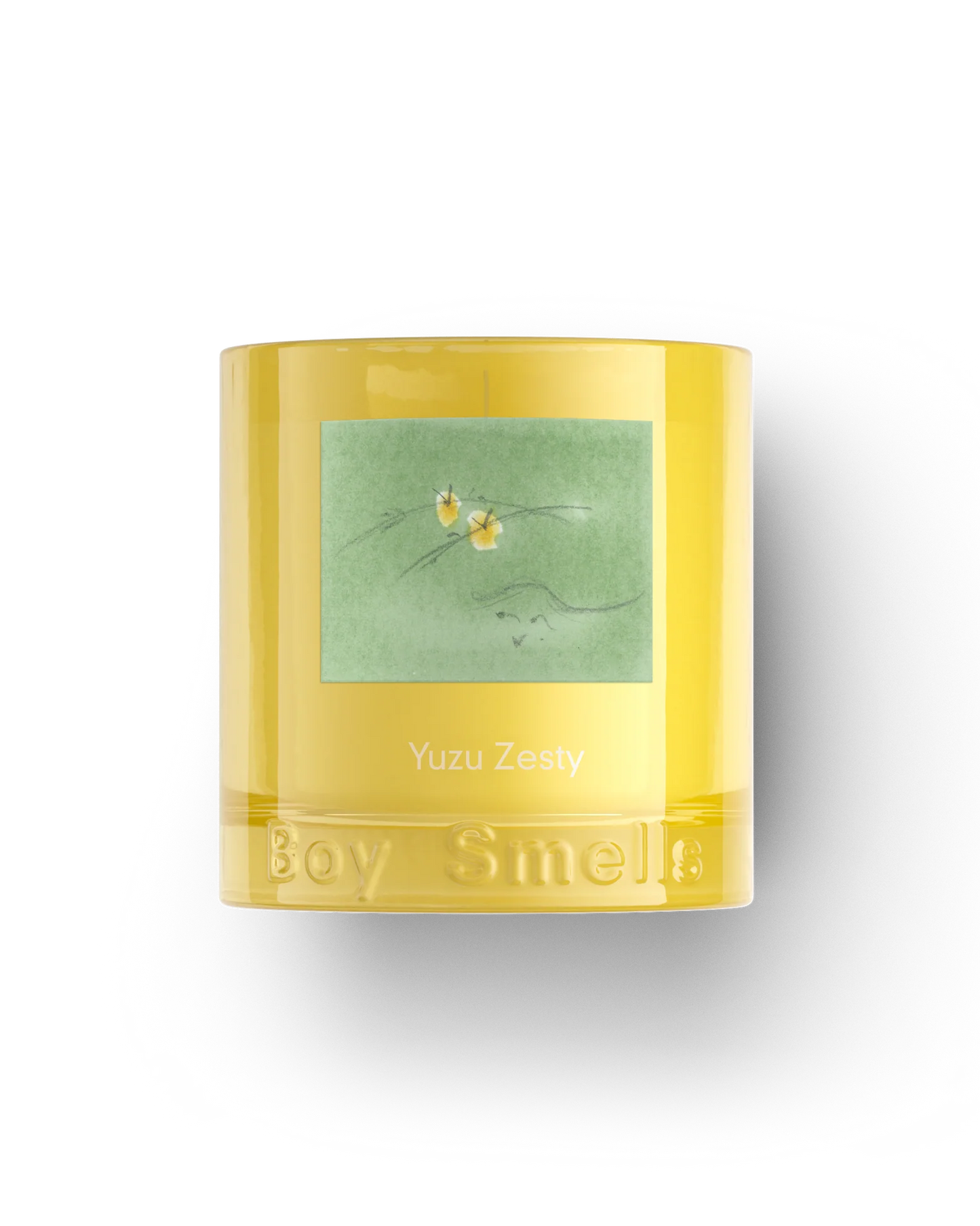 Yellow candle with green label featuring floral design on a white background