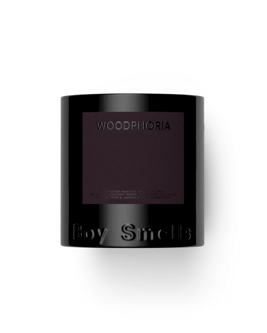 Black candle container with 'Woodphoria' and 'Boy Smells' branding on a white background