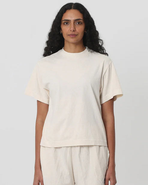 Woman wearing a beige t-shirt and shorts set on a white background