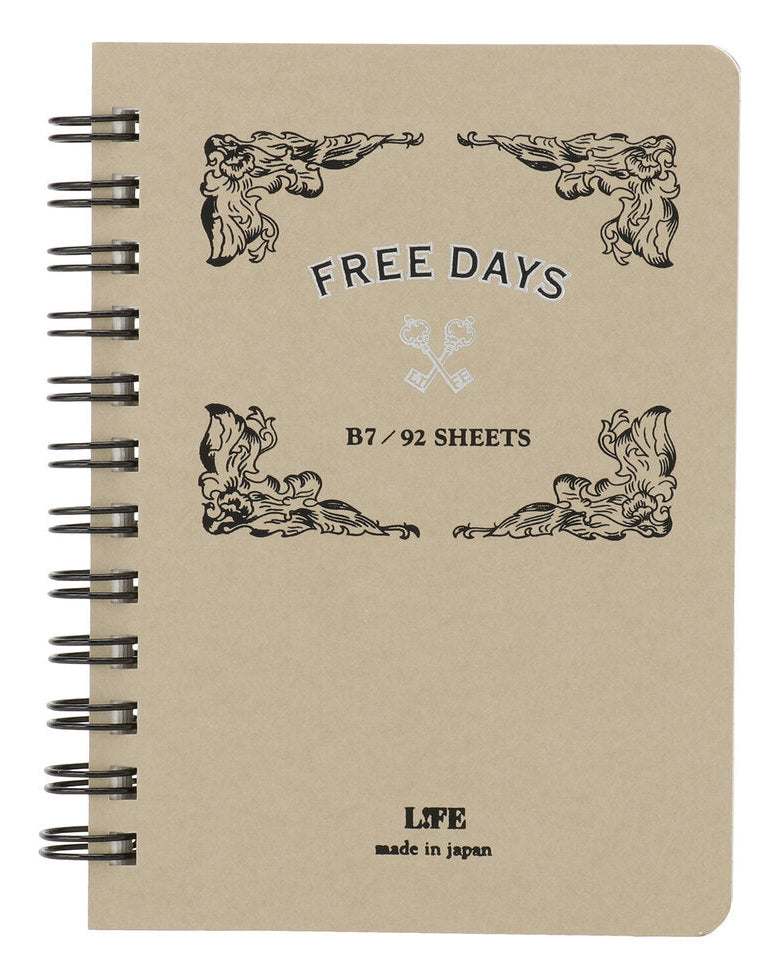 A beige spiral-bound notebook with black wire binding and printed decorative corner motifs. The cover reads 'FREE DAYS', 'B7 / 92 SHEETS', and 'LIFE made in japan'.
