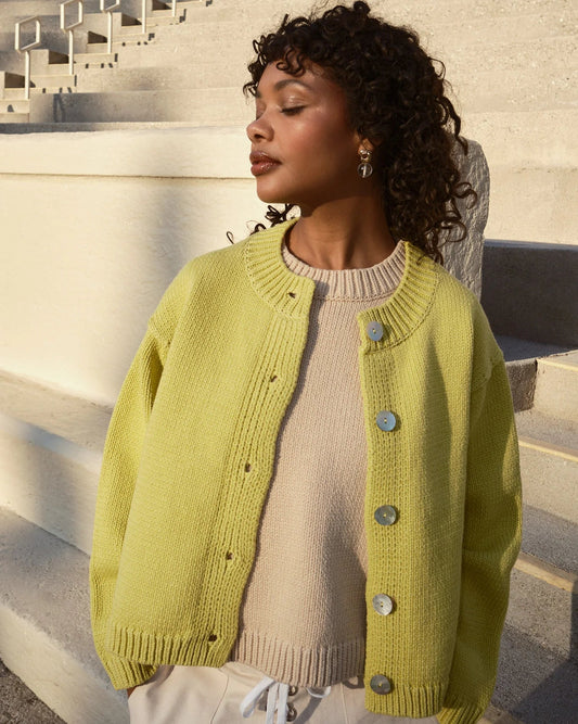 Woman wearing a green cardigan on stone steps