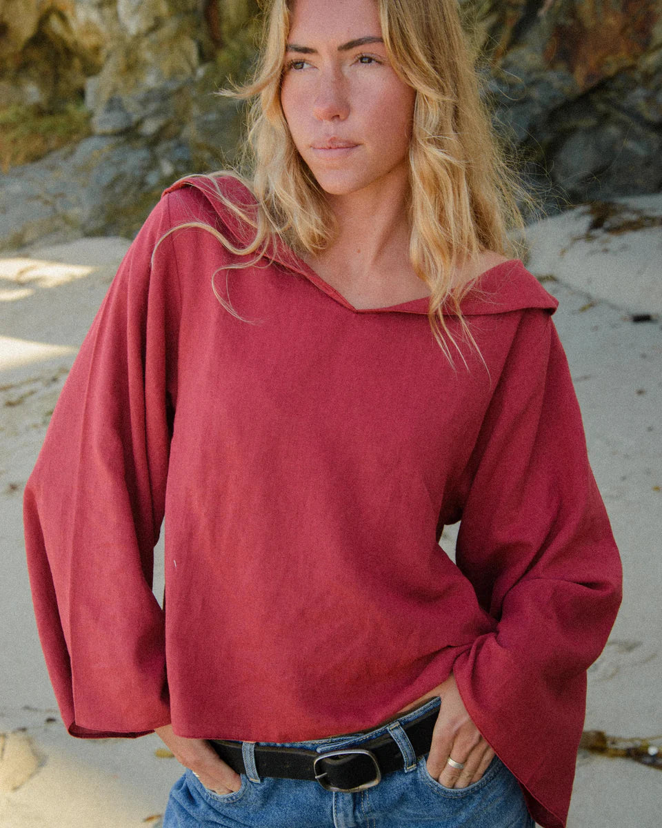 Woman wearing a red hoodie on a beach
