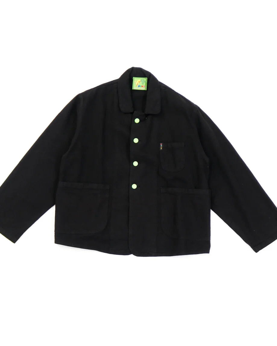 A black corduroy utility jacket with a button front, chest pocket, and lower patch pockets, laid flat on a white background.