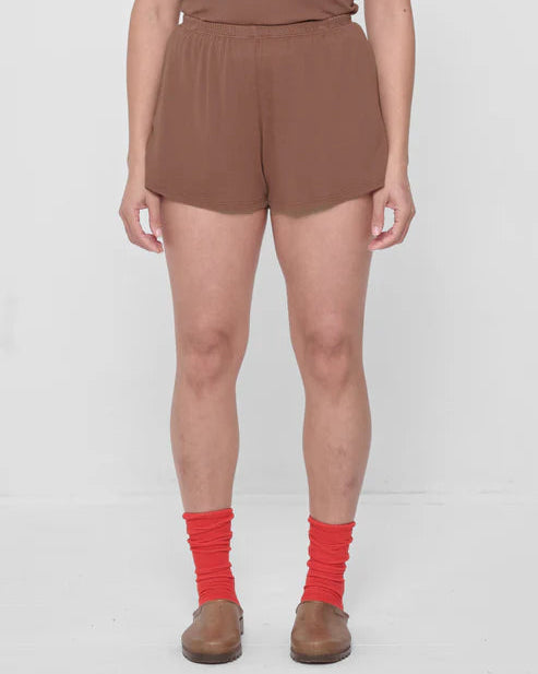 Person wearing brown shorts and red socks on a white background