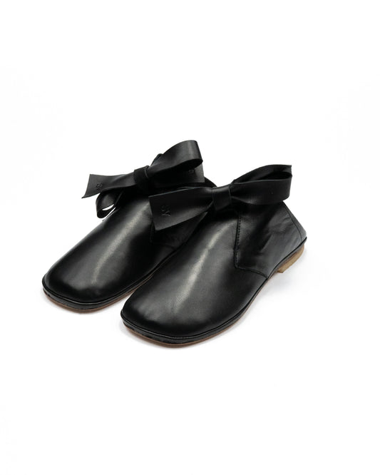 Simona Vanth Captain shoe in black leather, a desert boot-style silhouette with an oversized leather ribbon lace