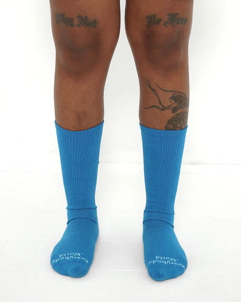 Blue socks worn by a person on a white background