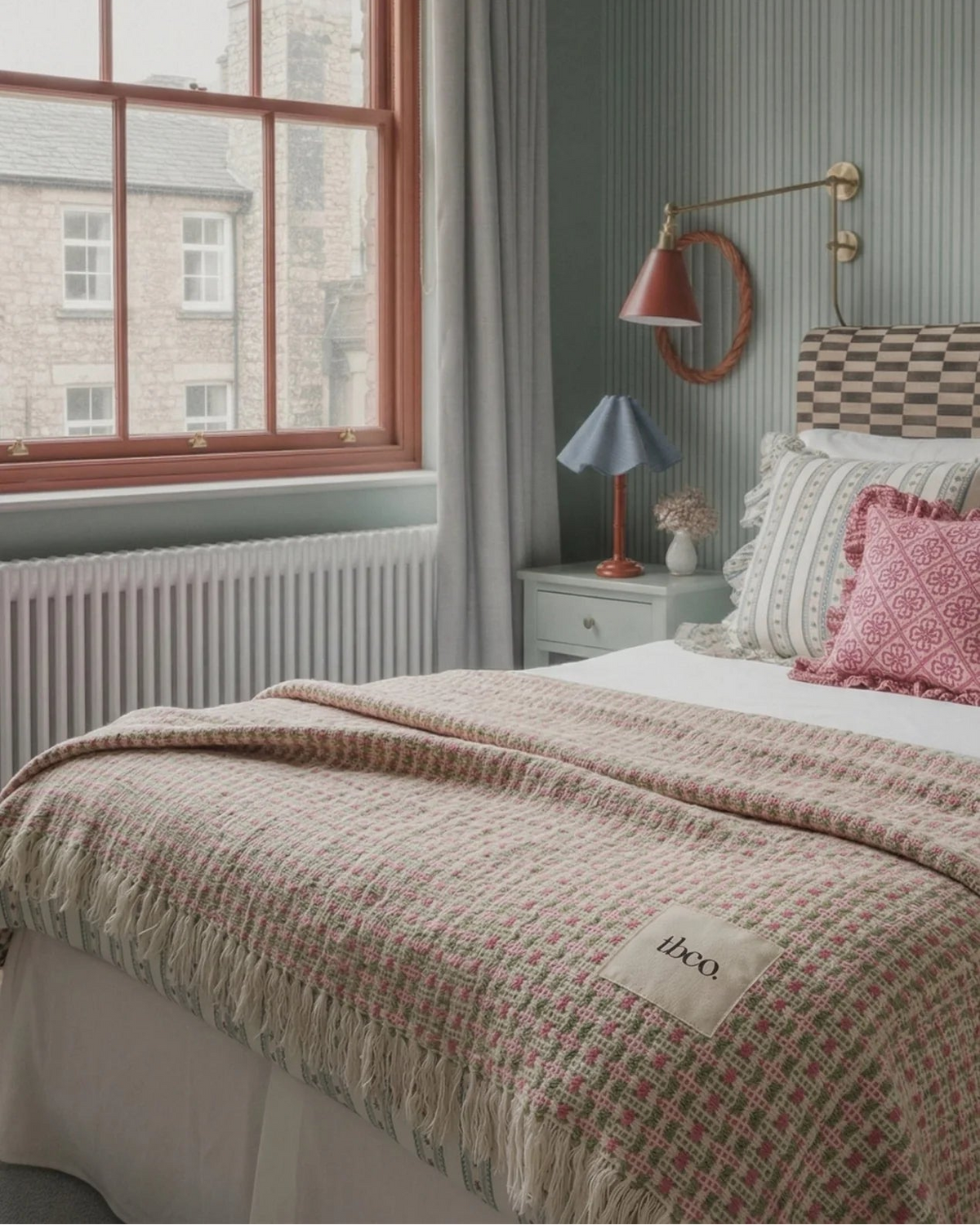 Cozy bedroom with a bed, lamp, and window view.