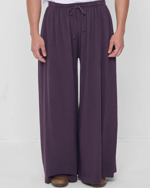 Person wearing purple wide-leg pants on a white background