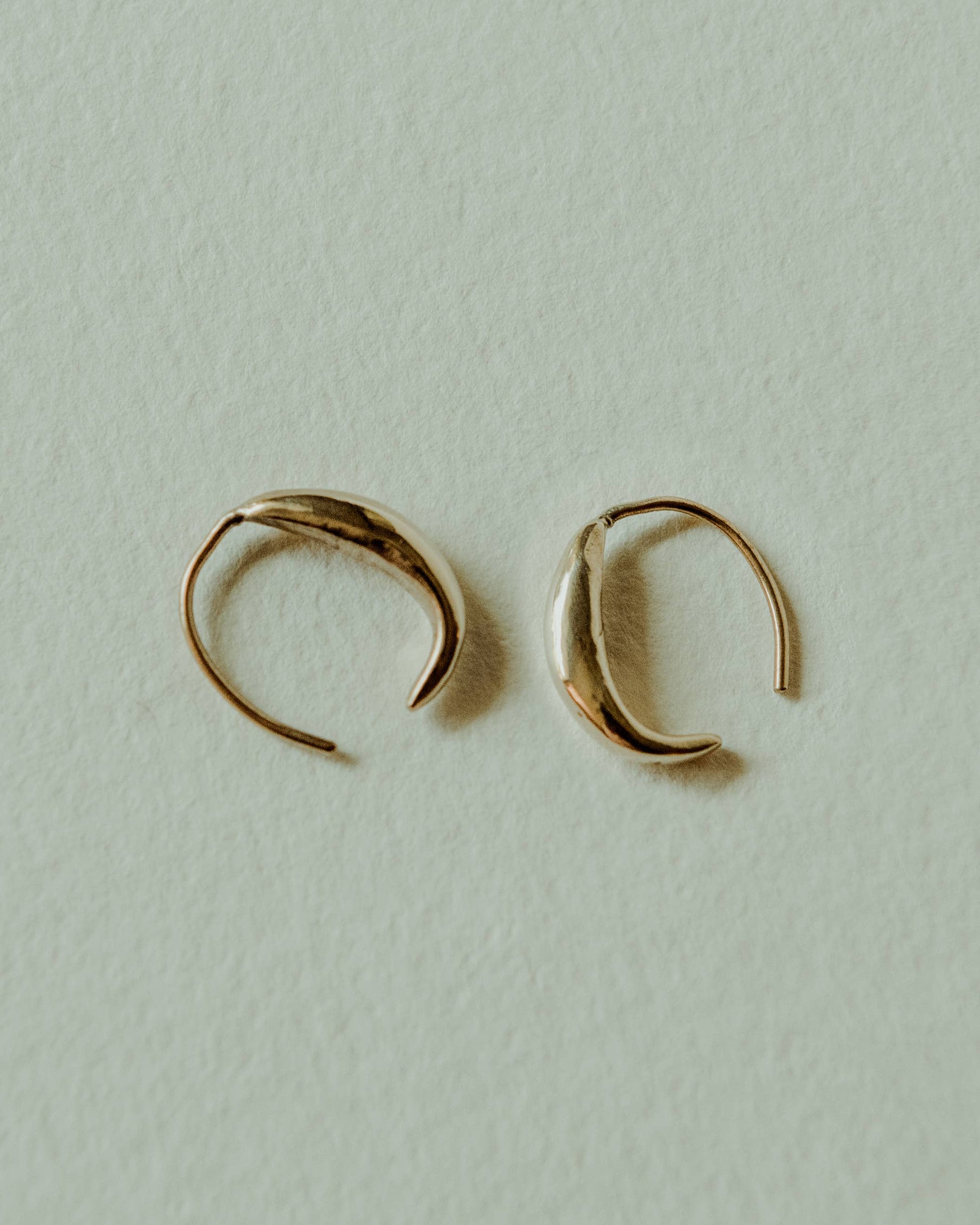 Gold hoop earrings on a light gray background