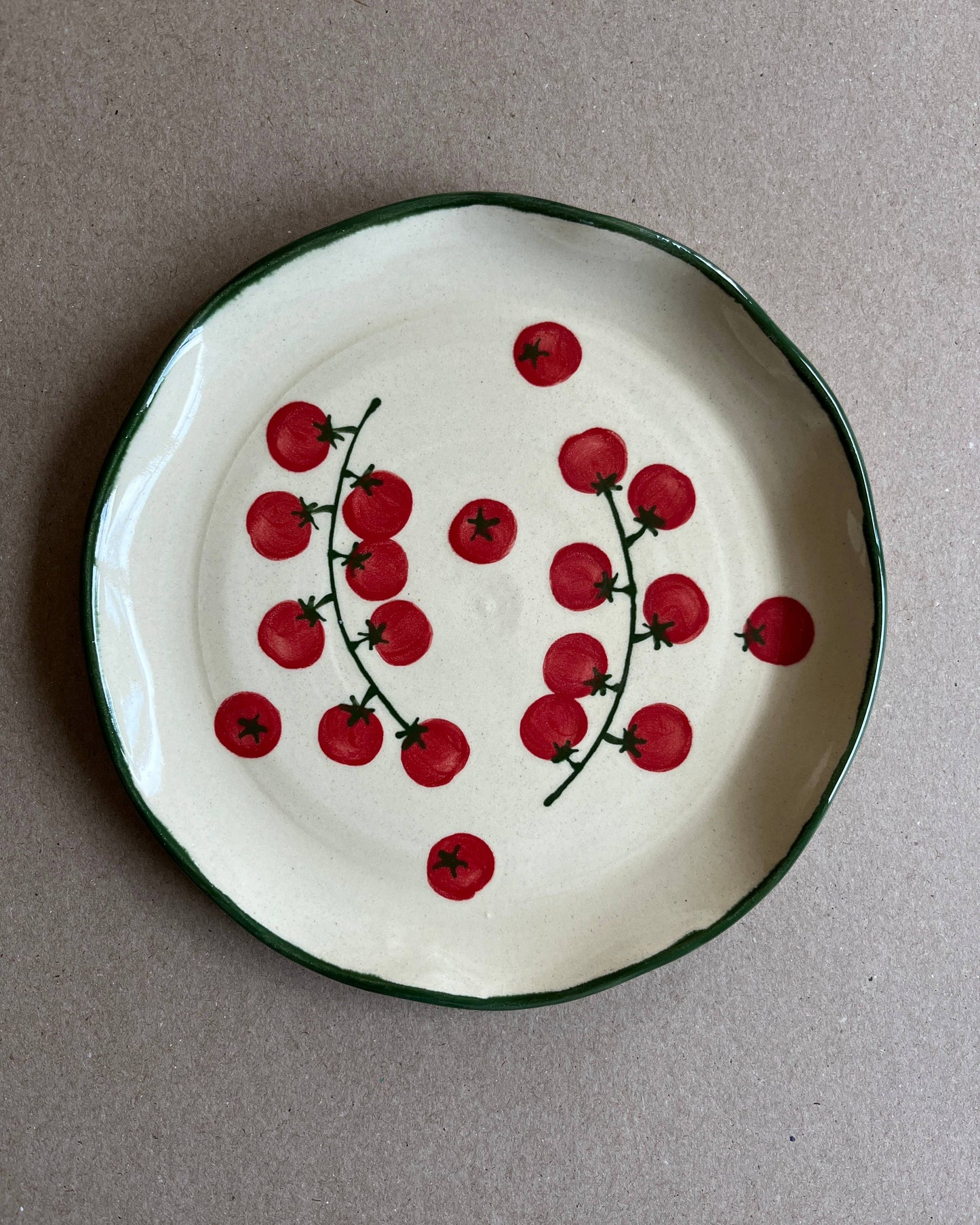 Ceramic plate with red cherry design on a gray background