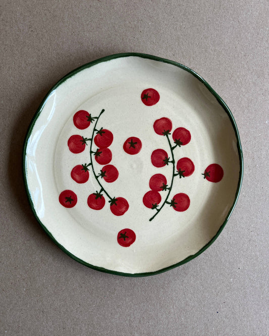 Ceramic plate with red cherry design on a gray background