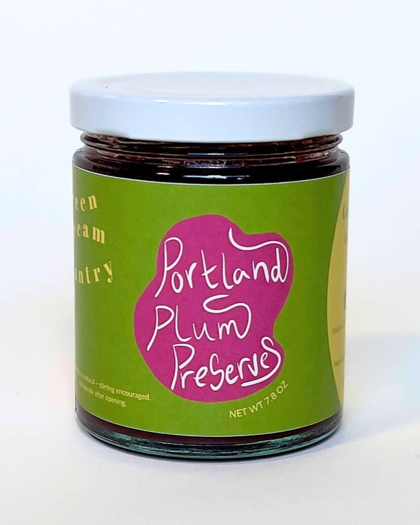 A jar of Portland Plum Preserves with a green label and a pink logo, topped with a white lid, on a white background.