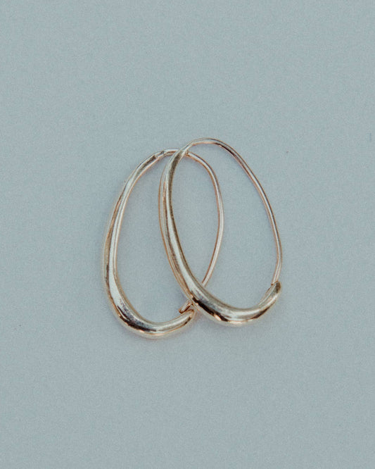 Gold hoop earrings on a light blue background