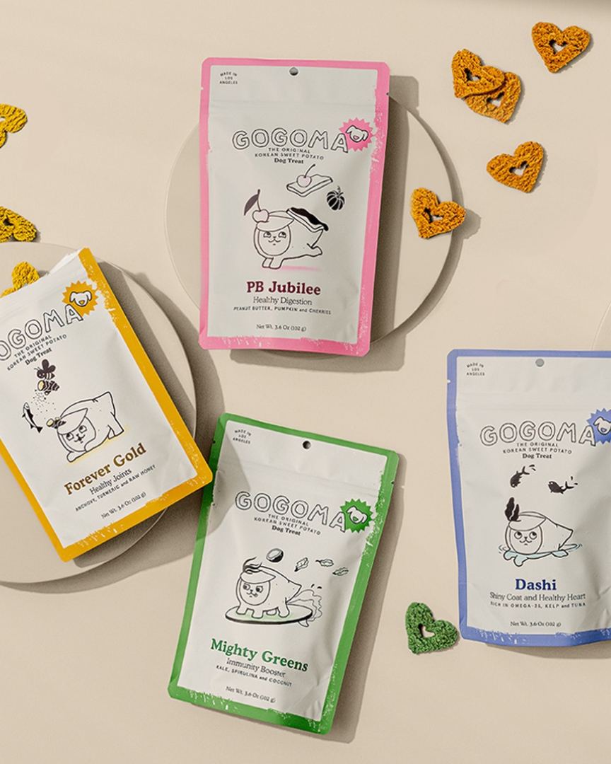 Four Gocoma snack packages on a beige background with decorative elements.