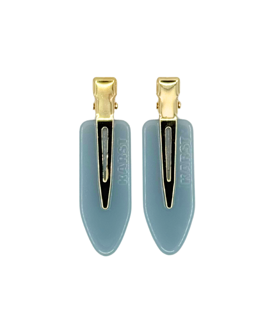 Pair of blue hair clips with gold clips on a white background