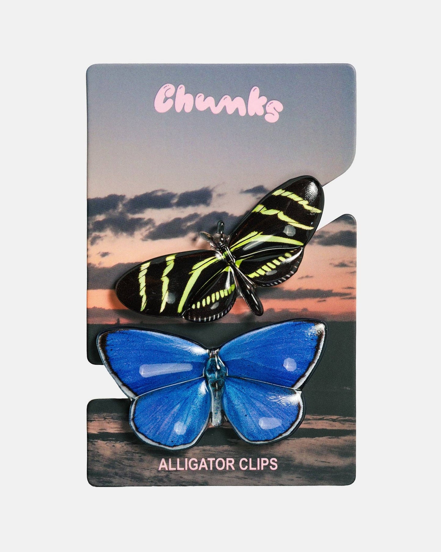 Two butterfly-shaped alligator clips by Chunks, displayed on a branded backing card. The top clip is black with neon yellow-green stripes, and the bottom clip is bright blue.