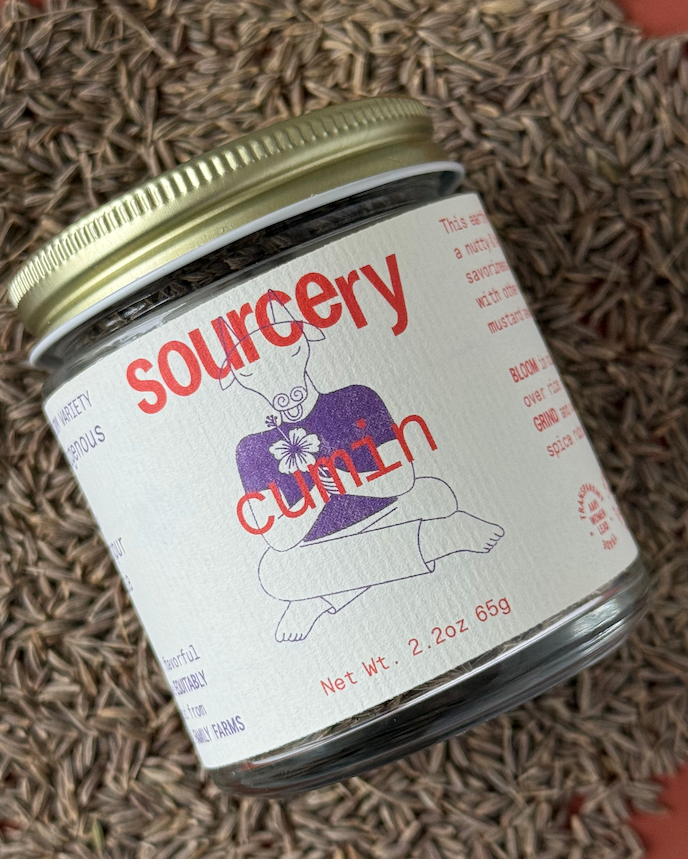 Jar of 'sourcery cumin' on a textured surface