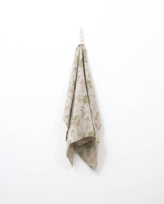 Floral-patterned towel hanging on a white background