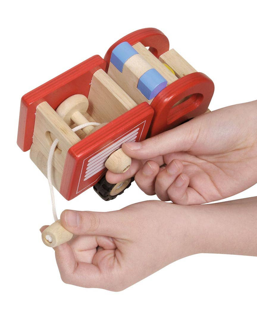 Wooden toy with red frame held by a child's hands on a white background