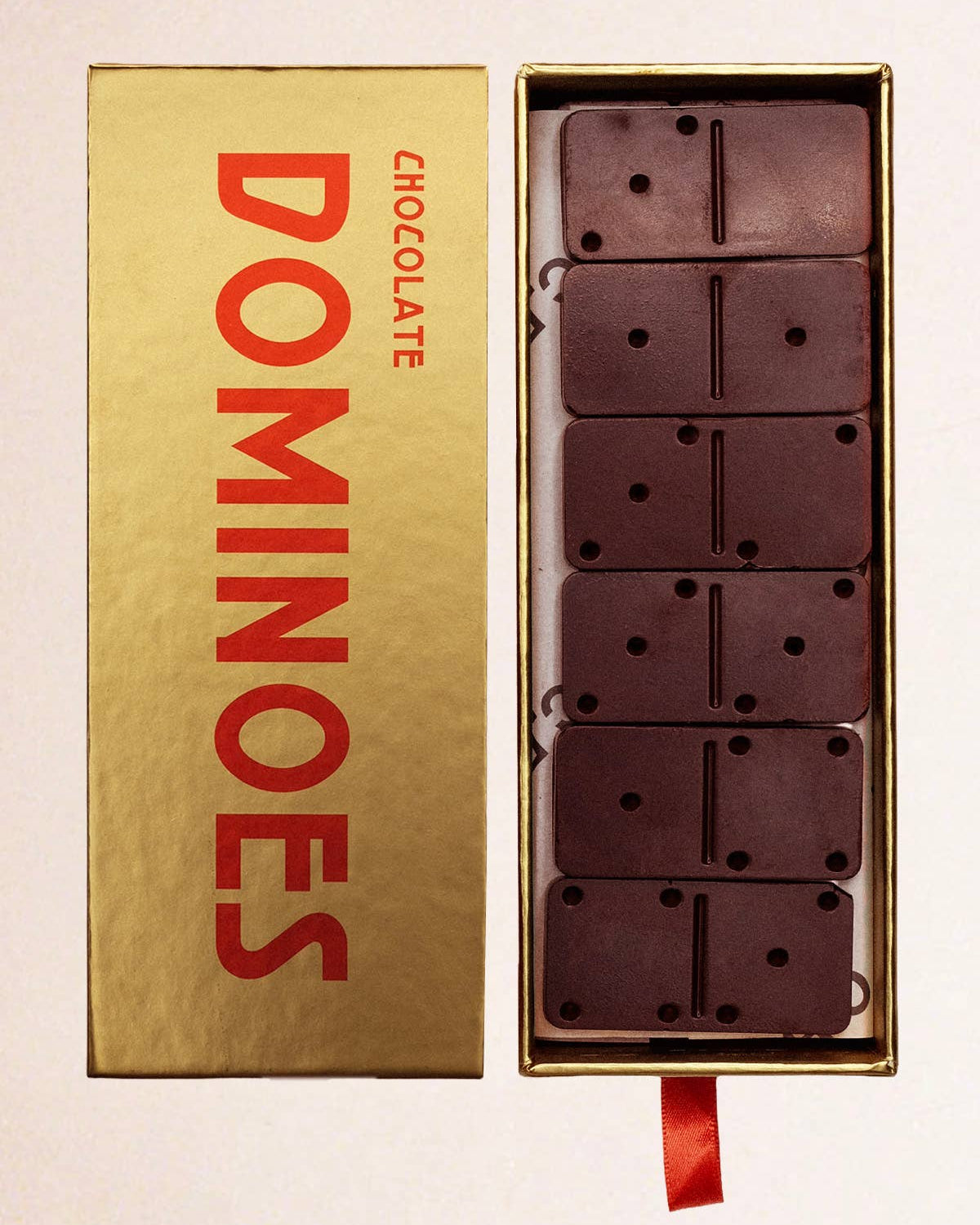Gold box of Dominoes chocolate bars on a light background