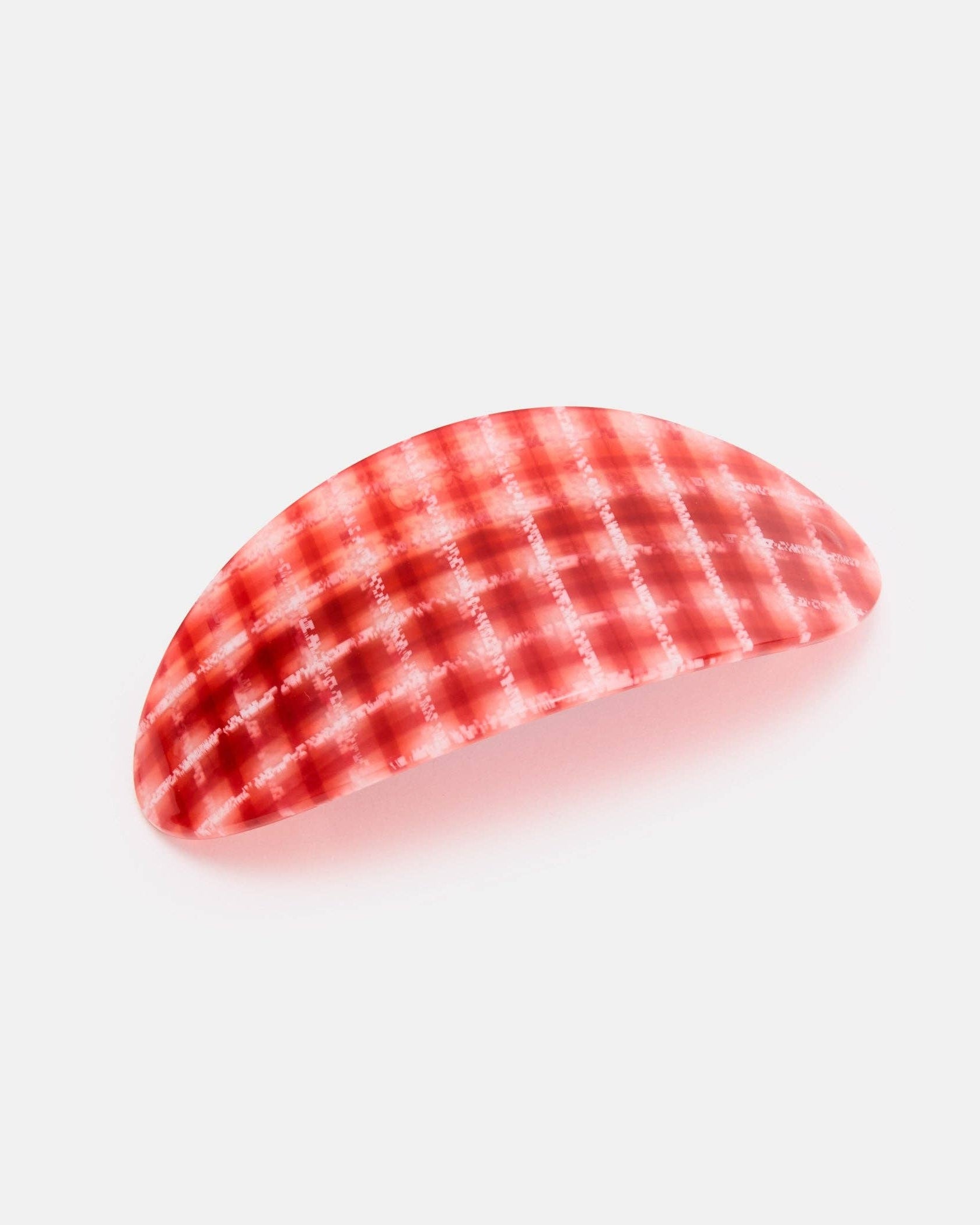Red and white checkered barrette on a light gray background