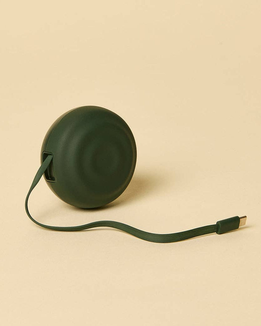Green retractable cable on a beige background