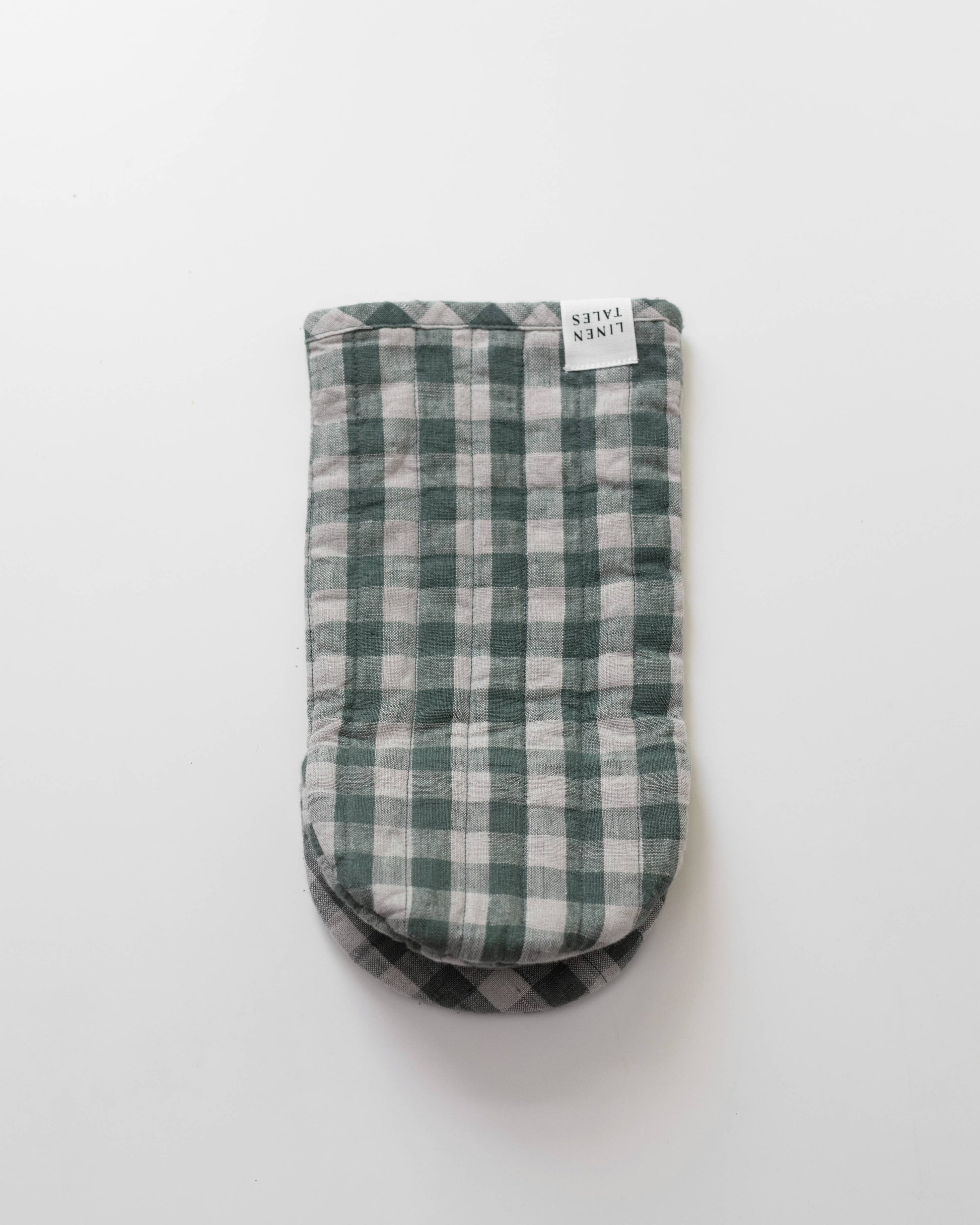 Green and white checkered oven mitt on a light gray background
