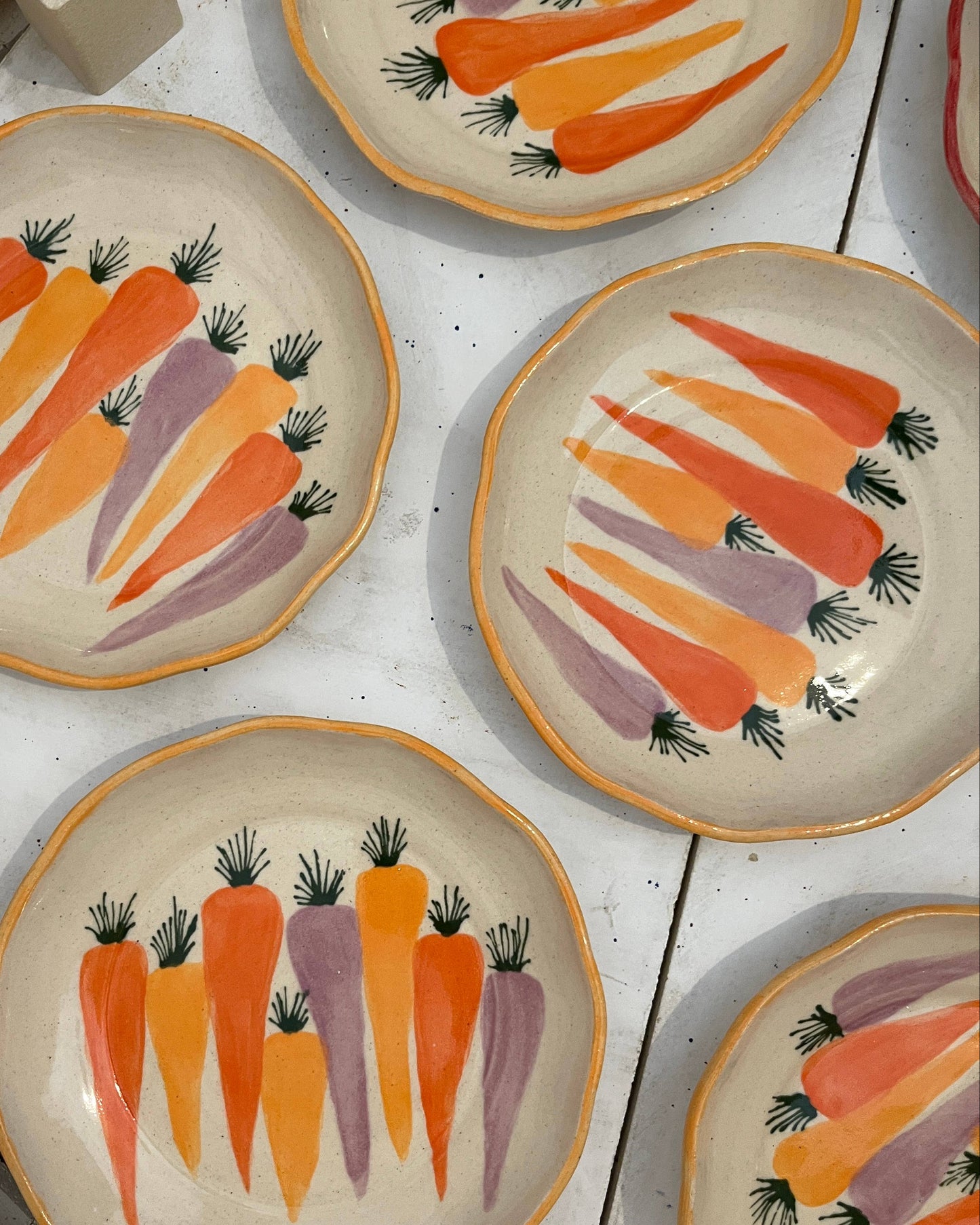 Set of ceramic plates with carrot design on a white surface